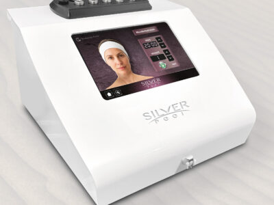 White beauty device with a tilted touchscreen showing a woman's face and microdermabrasion controls on the screen.